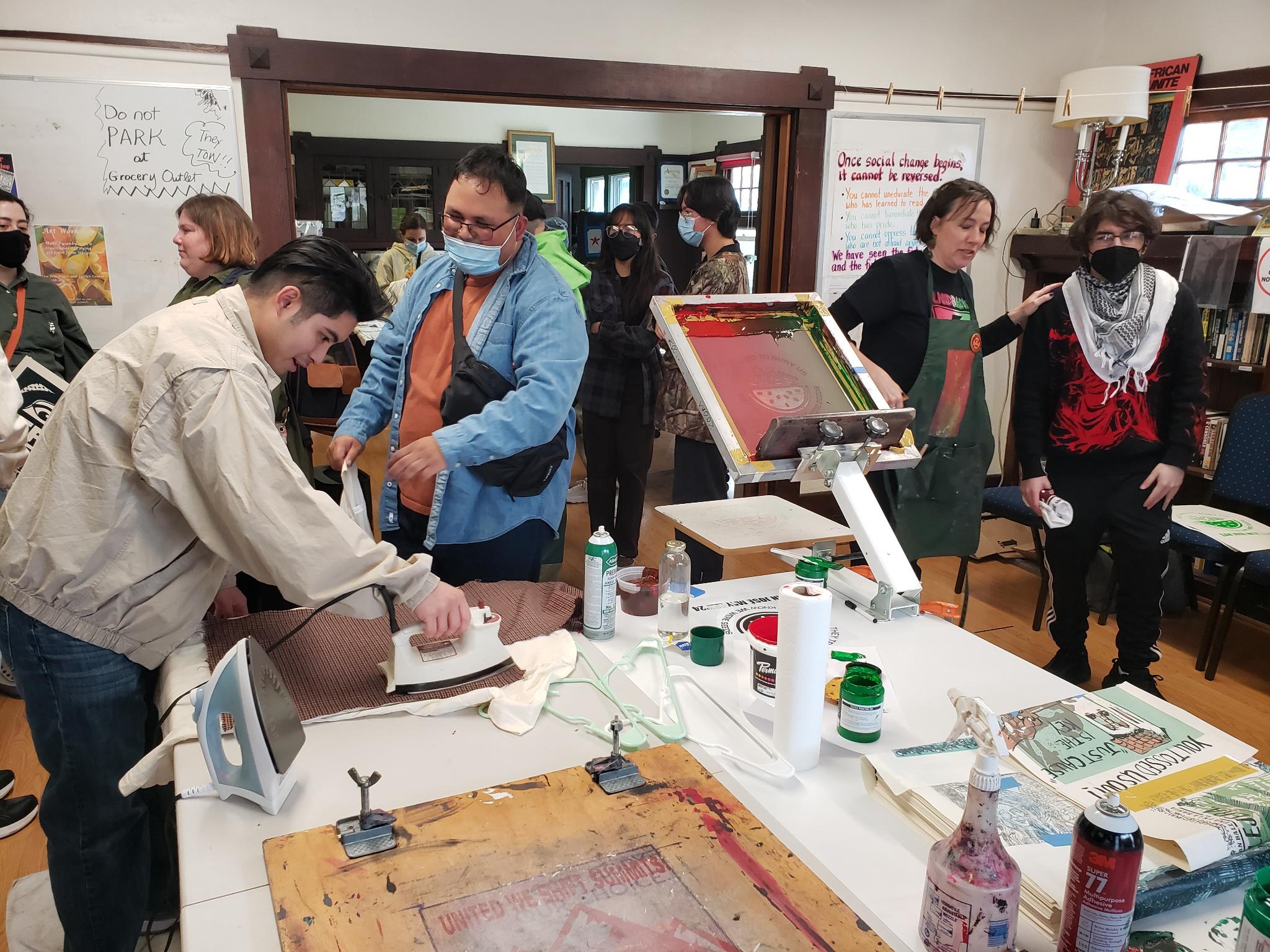 Room full of people screen printing posters